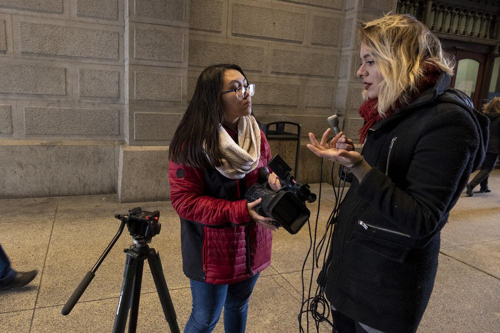 一名学生记者在街上与一名线人交谈.