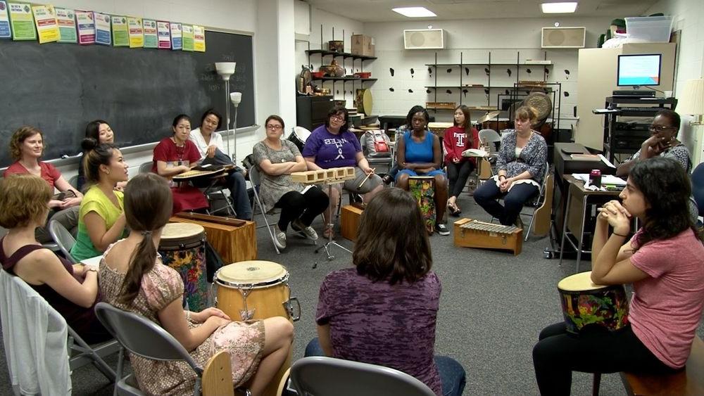 Music Therapy Jazz students sit in a circle in a classroom with different kinds of percussion instruments in front of them.